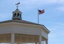 American flag flying on a cupola-topped building against a blue sky